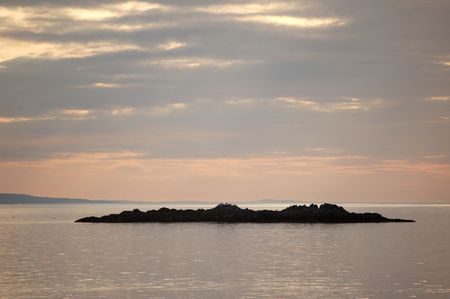 Sunset over a small island from Arisaig, Scotlandの写真素材