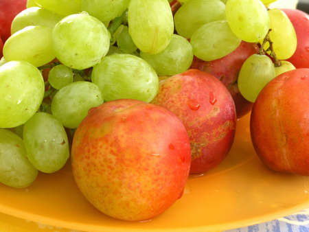 fresh fruits on yellow, plastic plateの写真素材