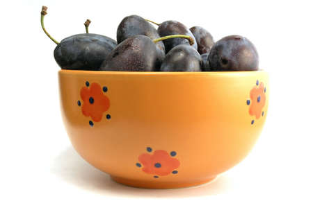 orange bowl full of plumsの写真素材