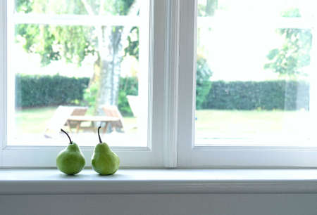 two, green pears on window sillの写真素材