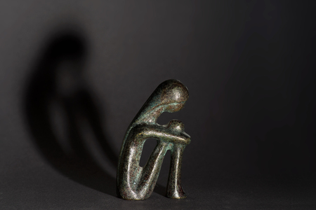 brass figure with dark shadowの写真素材