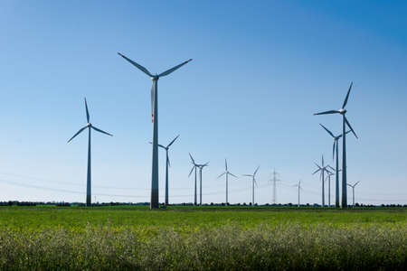 Wind power plants. Wind turbines powered by wind energy. Windmills in the fields. Environmentally friendly.の写真素材