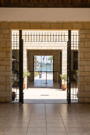 Entrance to the Paphos Archaeological Park, Cyprus. Stone buildings. Symmetry. View through the door to the sea.の写真素材