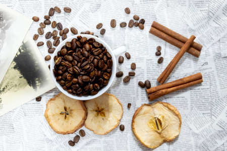 Afternoon black coffee in a white cup. Sweet dessert. Dried apples and cinnamon.の写真素材