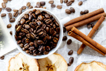 Afternoon black coffee in a white cup. Sweet dessert. Dried apples and cinnamon.の写真素材