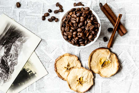 Afternoon black coffee in a white cup. Sweet dessert. Dried apples and cinnamon.の写真素材