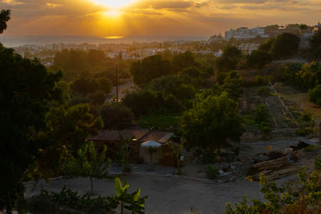 Beautiful sunset over the sea and the city. The orange sky is reflected in the water. Paphos, Cyprus.の写真素材