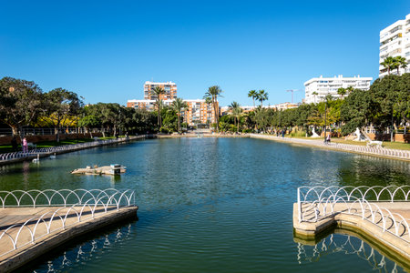 A large city park located around a picturesque lake. Malaga, Andalusia, Spain. The park has picnic areas and works of art.の写真素材