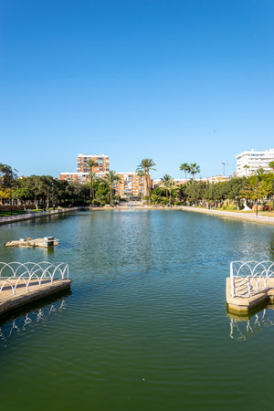 A large city park located around a picturesque lake. Malaga, Andalusia, Spain. The park has picnic areas and works of art.の写真素材