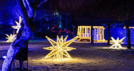Stars made of light illuminations. Colored lights and trees. Christmas and New Year decorations.の写真素材