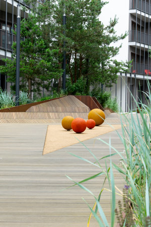 Outdoor Gardens Gdynia A group of orange spheres on a wooden platform in a park.の写真素材