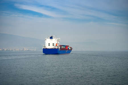 the blue container ship cruising at sea