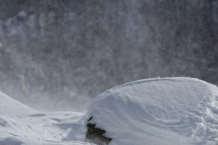 mountain landscape while snowing in winter time