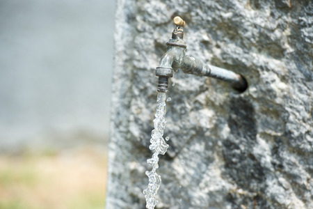 water falling from open tap in countryside