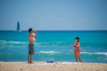 HONOLULU, USA - People having fun at waikiki beach in Hawaii Oahu islandのeditorial素材