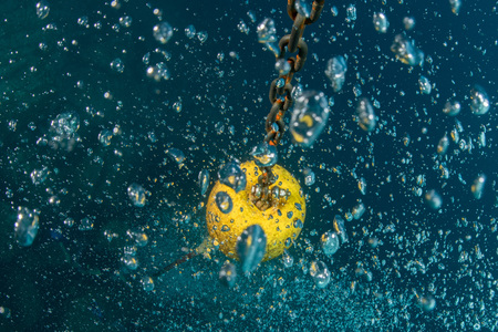 scuba diver bubbles coming from bottom to surface near ship chainの写真素材