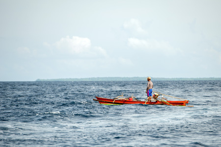 BUNAKEN, INDONESIA - APRIL, 5 2014 - fishing ship returning to fisherman village in Sulawesi Islandのeditorial素材