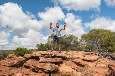 man jumping from red cliff in Australiaの写真素材
