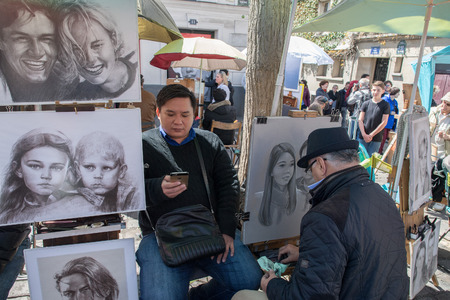 PARIS, FRANCE - MAY 1 2016 - Artist painting and drawing portraits on sunny sunday day in Montmartre Place du Tertre famous artist retreatのeditorial素材