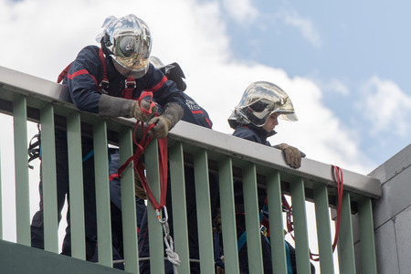 PARIS, FRANCE - MAY, 3 2016 - Firemen in action hanging from on a bridge  on river Seineのeditorial素材