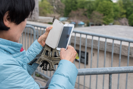 PARIS, FRANCE - MAY 2, 2016: Tour Eiffel town symbol on sunny day, not a lot of tourist after november terrorist attack, they are taking pictures and selfies using cellular phonesのeditorial素材
