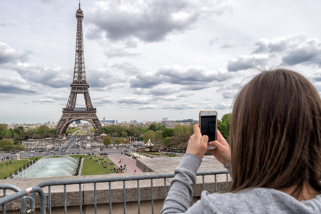 PARIS, FRANCE - MAY 2, 2016: Tour Eiffel town symbol on sunny day, not a lot of tourist after november terrorist attack, they are taking pictures and selfies using cellular phonesのeditorial素材