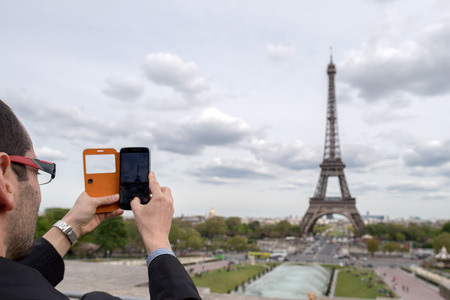 PARIS, FRANCE - MAY 2, 2016: Tour Eiffel town symbol on sunny day, not a lot of tourist after november terrorist attack, they are taking pictures and selfies using cellular phonesのeditorial素材