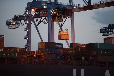 GENOA, ITALY - JULY 22 2016 - night harbor operation loading unloading cargos contanier in one of...