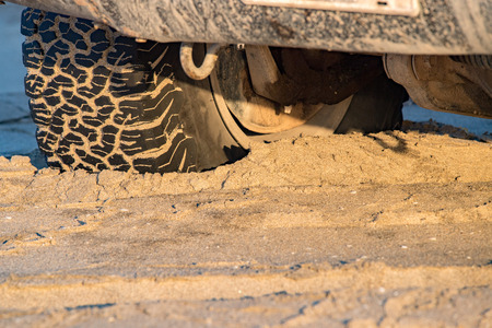 offroad car tire detail on sand close upの写真素材