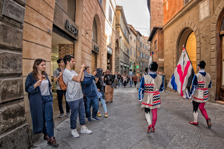 SIENA, ITALY - MARCH 25 2017 - Traditional flag wavers parade. 17 district of medieval town on parade in dome place preparing for worldwide famous horse race called Palioのeditorial素材