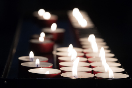 church candles weaving flames on black background