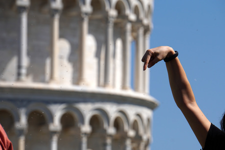 PISA, ITALY - SEPTEMBER 26 2017 - Tourist taking pictures while pushing and holding famous leaning tower in piazza dei miracoliのeditorial素材