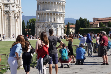 PISA, ITALY - SEPTEMBER 26 2017 - Tourist taking pictures while pushing and holding famous leaning tower in piazza dei miracoliのeditorial素材