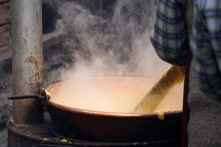 RANGO, ITALY - DECEMBER 1, 2017 - People cooking polenta traditional corn wheat meal at christmas market in the beautiful medieval villageのeditorial素材