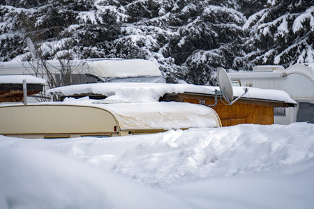 rv trailer caravan roulotte covered by snow in winter timeの写真素材