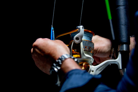 Fishing reel tackle isolated on black background
