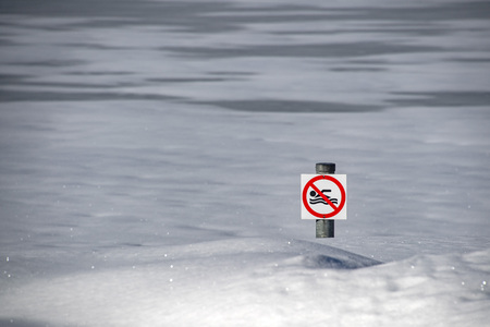 no swimming sign on frozen lake white snowの写真素材