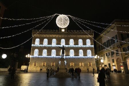 CHIAVARI, ITALY - DECEMBER 23, 2018 - Historical medieval town is full of people for christmas. The castle and the street with lights and ornaments. Shops under arcadeのeditorial素材