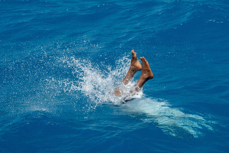 Young maldives man diving from boat in turquoise crystal watersの写真素材