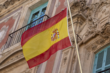Waving spanish flag on old buildingのeditorial素材