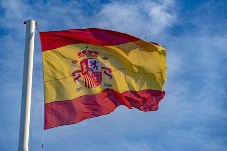 Waving spanish flag on sky background