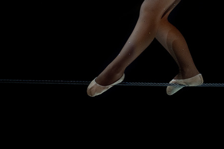 circus equilibrist steel wire artist feet detail on black backgroundの写真素材