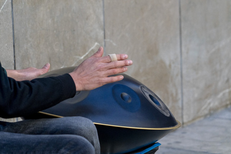 street performer playinh hang metal drum with hands