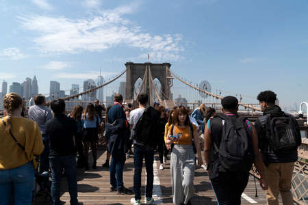 NEW YORK, USA, MAY 2 2019 - Brooklyn bridge full of tourists walking on sunny day