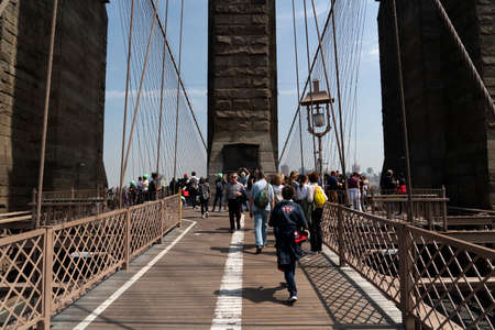 NEW YORK, USA, MAY 2 2019 - Brooklyn bridge full of tourists walking on sunny dayのeditorial素材