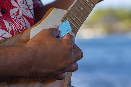 old man hands playing hukulele in Bora Bora french polynesia