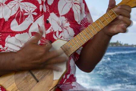 old man hands playing hukulele in Bora Bora french polynesiaの写真素材