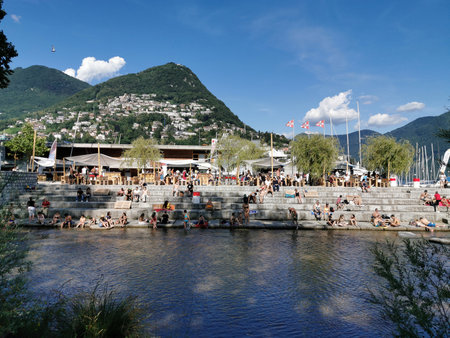 LUGANO, SWITZERLAND - JUNE 23 2019 - Lugano view cityscape from the lake full of people on sunday summer sunny dayのeditorial素材