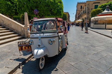 NOTO, ITALY, JULY 2 2019 - noto sicily baroque town tourist with pictoresque vespa ape car