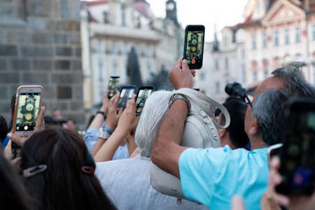 PRAGUE, CZECH REPUBLIC - JULY 17 2019 - Medieval tower clock full of tourist with smartphones. When the clock strikes the hour, the procession of the Twelve Apostles sets in motion.のeditorial素材